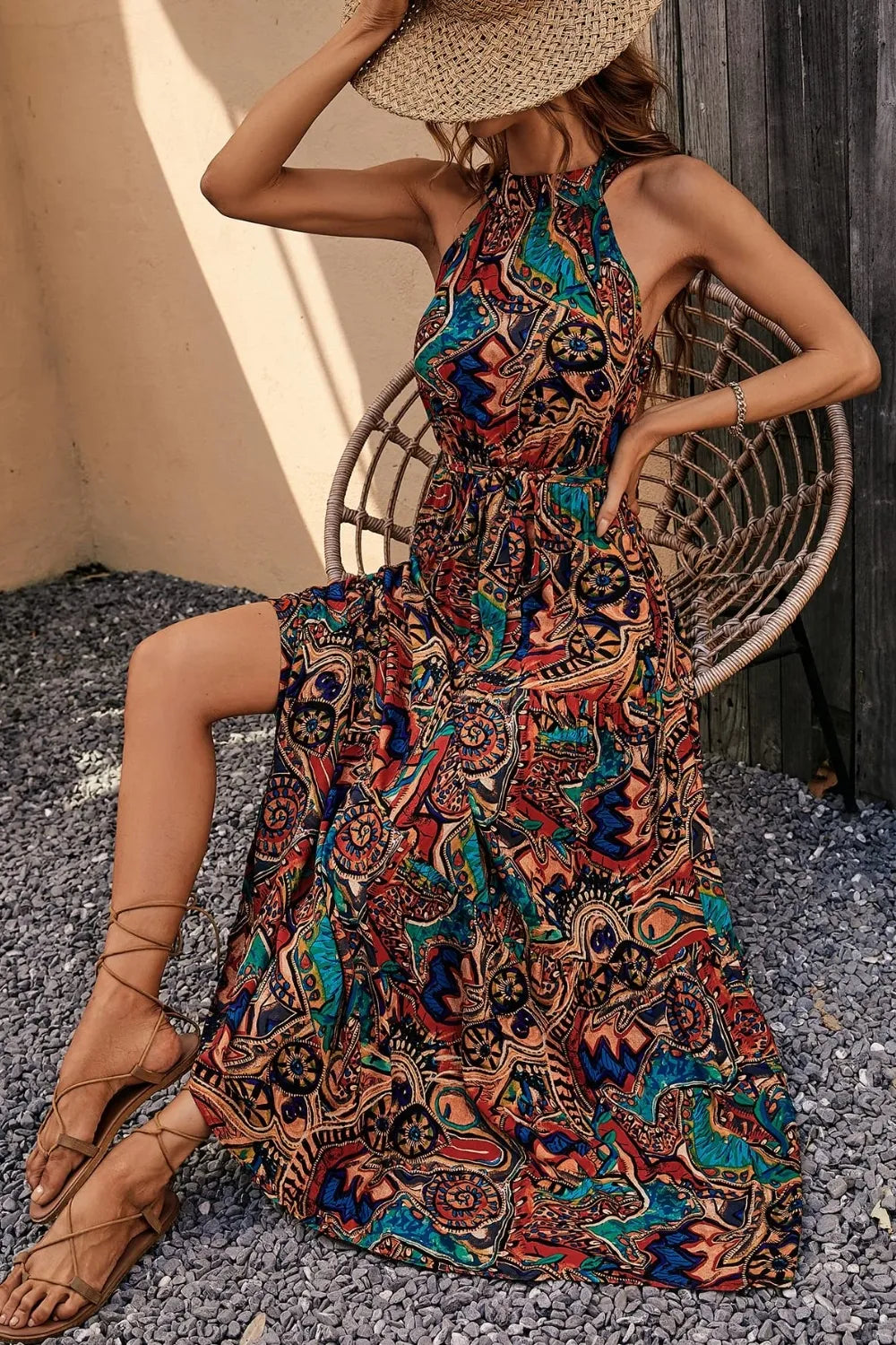 Model wearing tied floral sleeveless dress outdoors, showcasing casual summer style and flattering fit