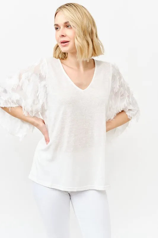 Close-up of feather detail on elegant women’s blouse